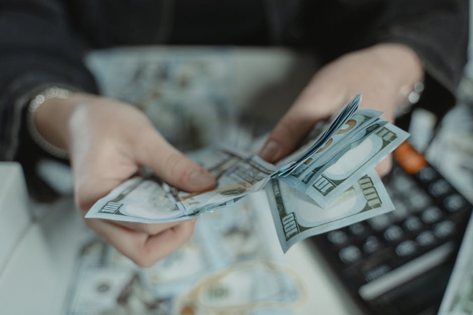 책상 위 가계부, 통장, 스마트폰으로 돈을 관리하는 모습